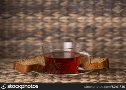 Tea and cake on wooden table in front of a wooden background