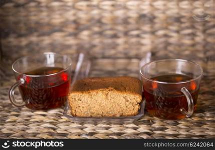 Tea and cake on wooden table in front of a wooden background