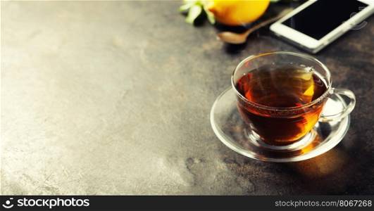 tea and mobile phone on dark rustic background