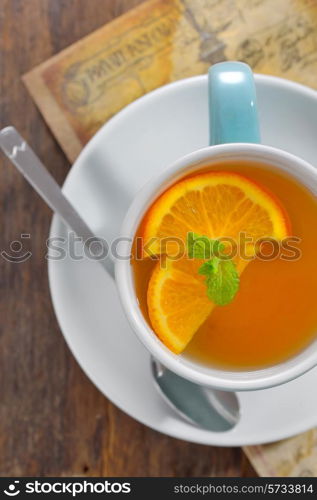 Tea and orange slices on old wood table