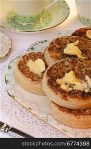 Tea and toasted crumpets with lashings of melting butter for Breakfast. A crumpet is a savoury griddle cake made from flour and yeast. It is eaten mainly in the United Kingdom and other nations of the Commonwealth.