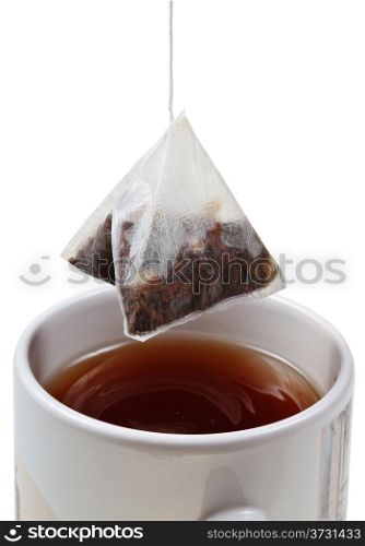 tea bag over brewing tea in mug close up isolated on white background