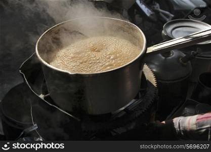 Tea boiling in saucepan at market stall