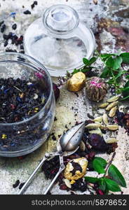 tea brew. Various dry tea brew on iron background with tea paraphernalia.