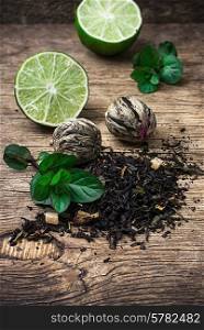 tea brew with lime and mint on wooden background in country style.Selective focus. tea brew with lime and mint on wooden background