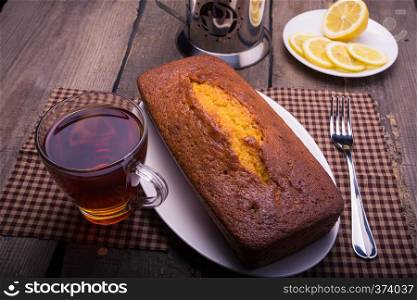 tea, cake and lemons lying on an obsolete wooden table