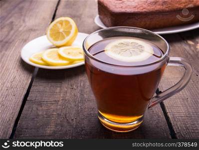 tea, cake and lemons lying on an obsolete wooden table