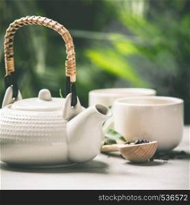 Tea composition on tropical leaves background- healthy life and relaxation concept. Tea composition on tropical leaves background, close up