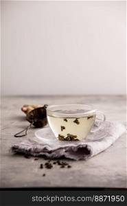 Tea composition with Cup of green tea against the white wall. Cup of green tea against the white wall