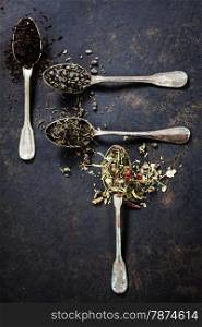 Tea composition with Different kind of tea and old spoons on dark background