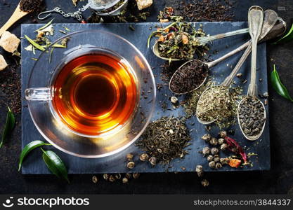 Tea composition with old spoon on dark background