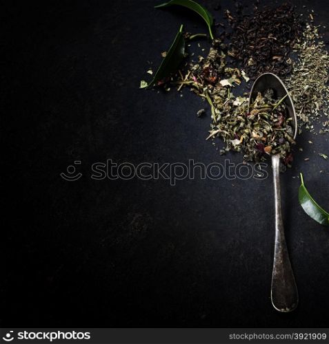 Tea composition with old spoon on dark background