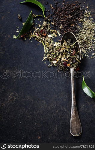 Tea composition with old spoon on dark background