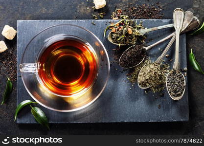 Tea composition with old spoon on dark background