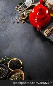 Tea composition with red teapot on dark background