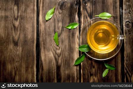 Tea Cup with leaves. On wooden background.. Tea Cup with leaves.