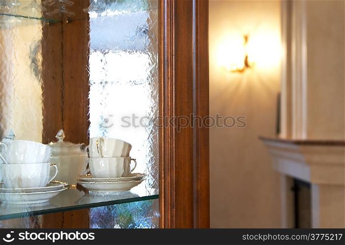 Tea cups behind glass in a kitchen case