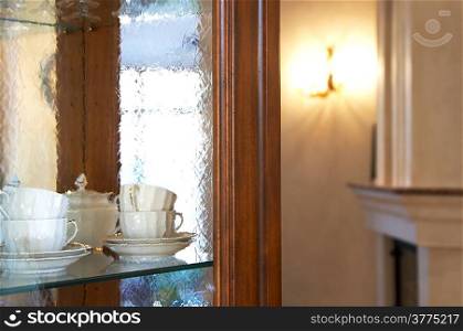 Tea cups behind glass in a kitchen case