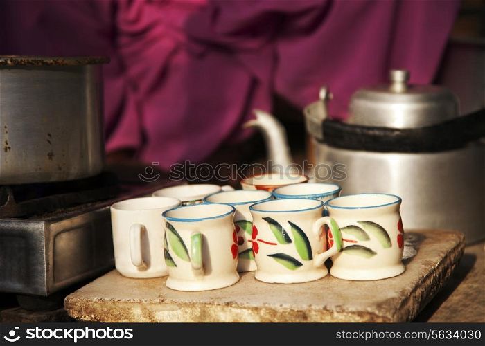 Tea cups , pan on stove and kettle at street market stall