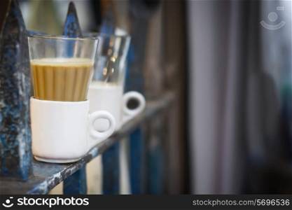 Tea glasses in cup on railing