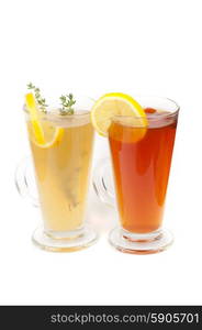 Tea glasses . Two tea glasses with thyme lemon and briar on a white