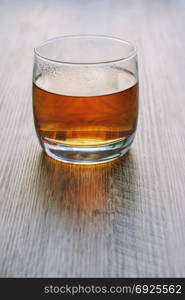 Tea in a glass on a wooden table. Hot tea in a glass, on a wooden table, in backlight.