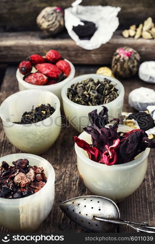 tea leaves for brewing. Tea leaves of different varieties in the stacks of custard and spoon