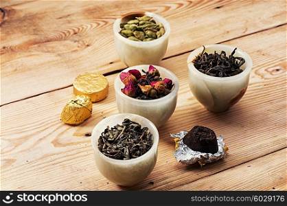 tea leaves. range of different varieties of tea leaves on wooden background