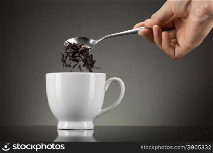 tea pour out into white cup on grey