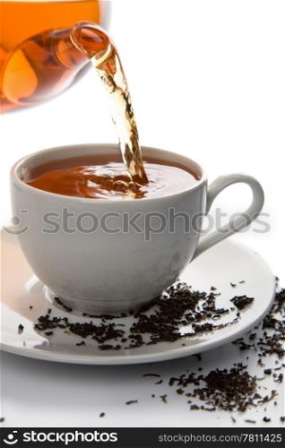 tea pouring into white cup isolated