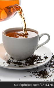 tea pouring into white cup isolated