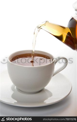 tea pouring into white cup isolated