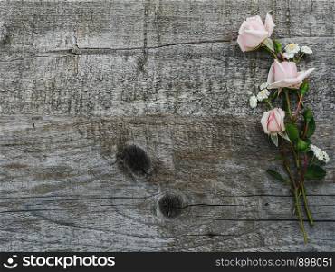Tea roses of pale pink color, lying on unpainted boards. Beautiful blooming bouquet. Place for your inscription. Top view, close-up. Congratulations to family, relatives, friends and colleagues. Beautiful bouquet of bright flowers and notepad