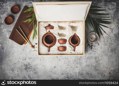 Tea set in the box on concrete background, flat lay, copy space. Tea set in the box on concrete background