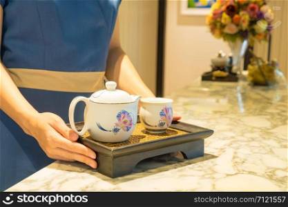 Tea set in the hands of the massager