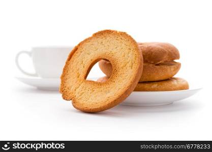 Tea time. Bread and bakery: high key image of toasted bagels on a plate and tea cup, isolated on white background