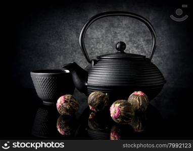 Tea utensil and buds on a black background