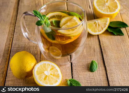 Tea with lemon and mint in a transparent cup. Alternative medicine. Hot drink for relaxation.. Tea with lemon and mint in transparent cup. Alternative medicine. Hot drink for relaxation.