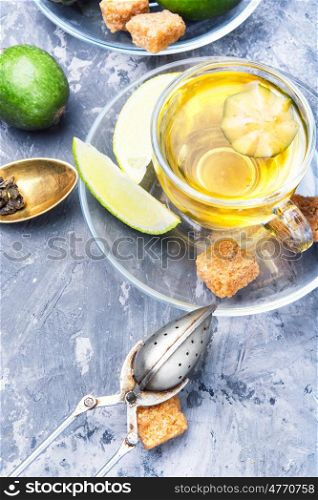 Tea with lime and feijoa. Hot tea with feijoa and lime on blue background