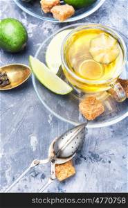 Tea with lime and feijoa. Hot tea with feijoa and lime on blue background