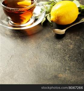 Tea with mint and lemon on rustic background