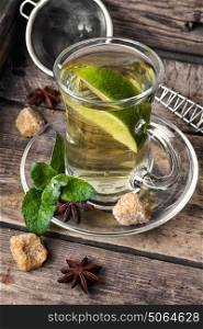 tea with mint and lemon. tea brewed with lime and mint on wooden background