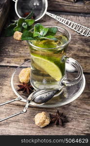 tea with mint and lemon. tea brewed with lime and mint on wooden background