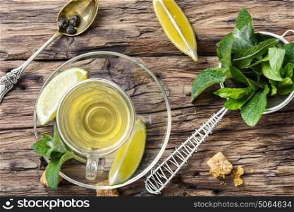 Tea with mint and lemon. tea brewed with lime and mint on wooden background