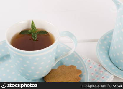 Tea with mint cookies served in a porcelain cup and saucer