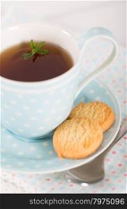 Tea with mint cookies served in a porcelain cup and saucer