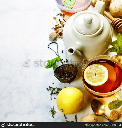 Tea with mint, ginger and lemon on marble background