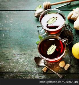 Tea with mint, ginger and lemon on old wooden table