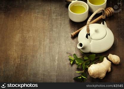 Tea with mint, ginger and lemon on wooden background