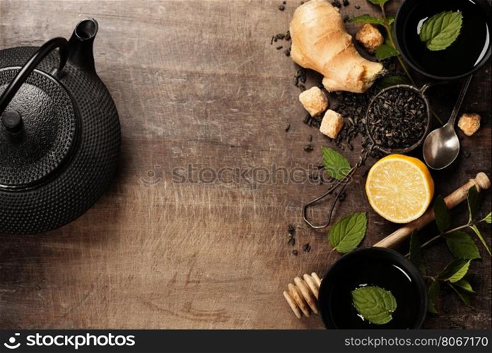 Tea with mint, ginger and lemon on wooden background